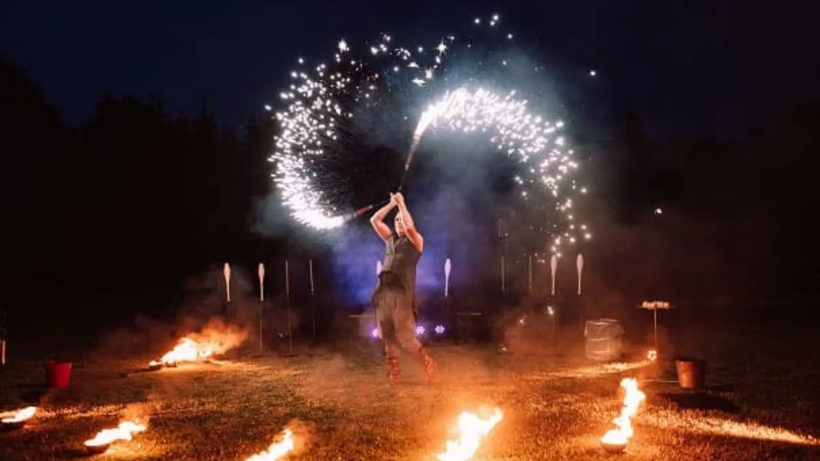 Artiste jonglant avec le feu et des étincelles lors d’un spectacle de cirque de rue
