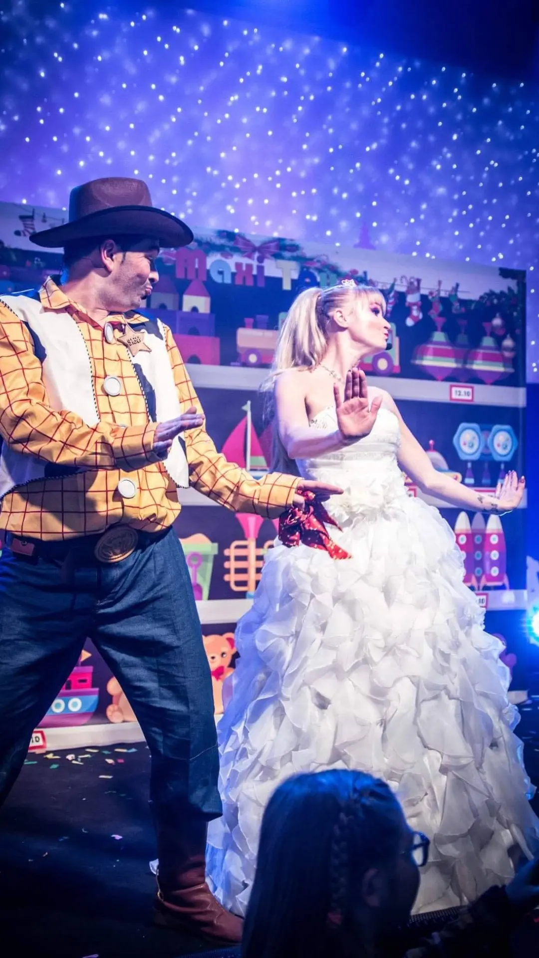 Deux artistes du spectacle Les Jouets de Noël sur scène devant un public d’enfants